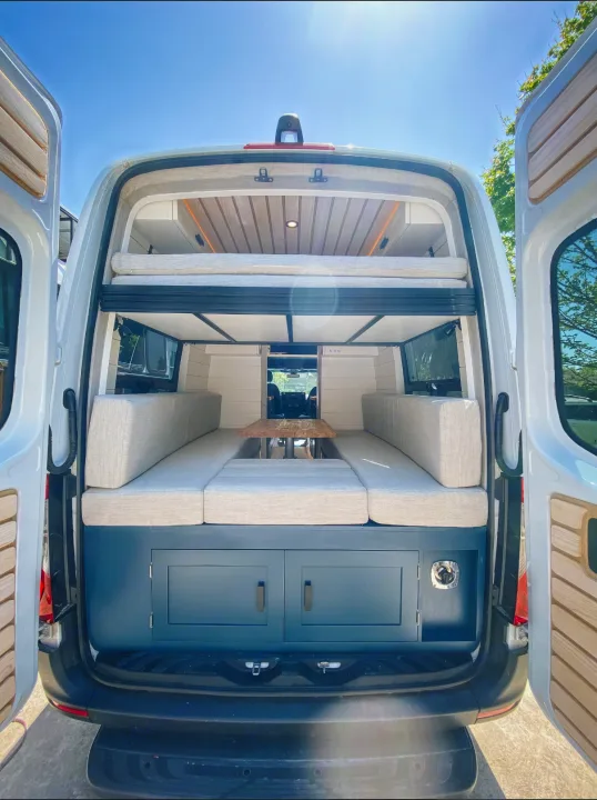 Step inside this custom rv rental camper van, featuring a versatile bed/seating area, warm wood ceiling, and rear storage.. Mercedes-Benz Sprintervan 2019