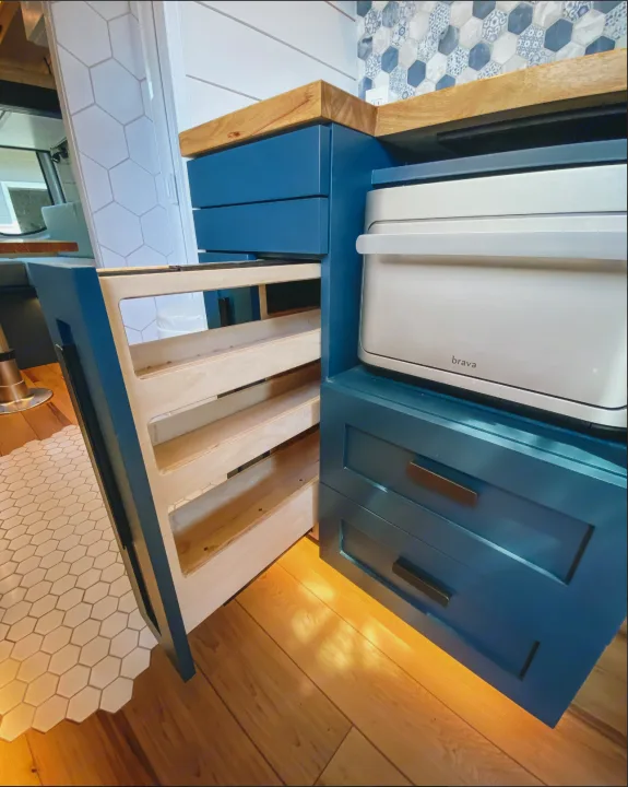 RV rental kitchen: deep teal cabinets, warm wood counters, pull-out spice rack, and a silver Brava oven.. Mercedes-Benz Sprintervan 2019