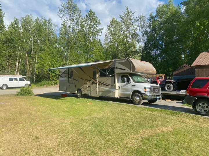 Experience outdoor adventure with this RV rental! A Winnebago Minnie Winnie parked at a campsite surrounded by trees.. Winnebago Minnie Winnie 2019