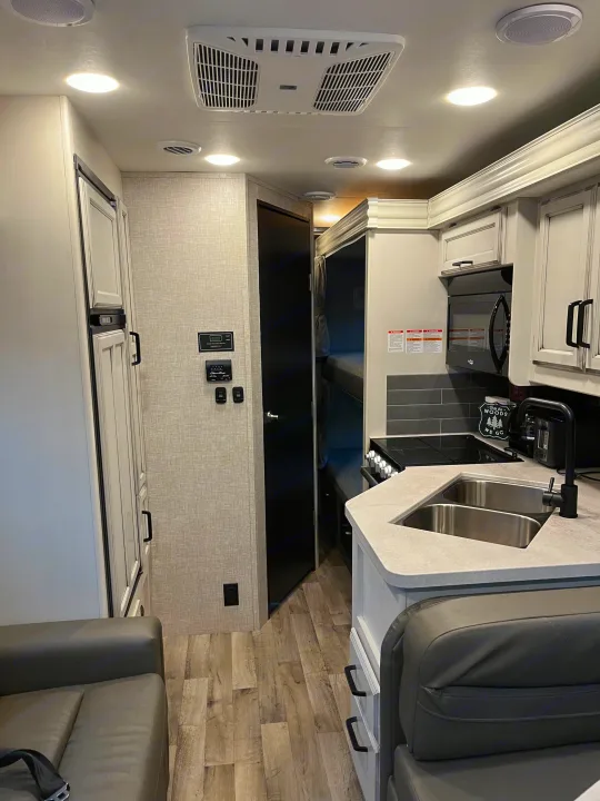 Step inside this modern RV rental! Features a full kitchen with a double sink, living space, and bunk beds, perfect for your next adventure.. Jayco Redhawk 2021