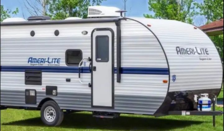 A white and blue Ameri-Lite Super-Lite travel trailer, an ideal rv rental. Visible are its door, windows, and AC unit.. Gulf Stream Ameri-Lite Super Lite 2021