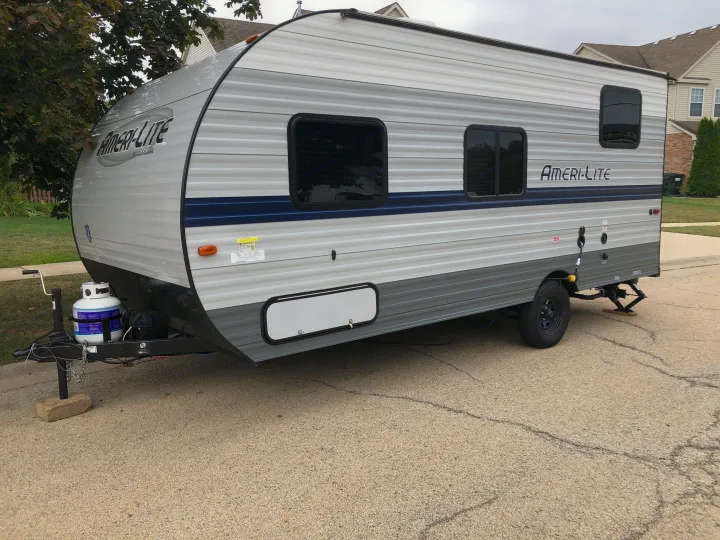 Ameri-Lite travel trailer, ideal for RV rental. This silver & blue recreational vehicle is parked on asphalt.. Gulf Stream Ameri-Lite Super Lite 2021