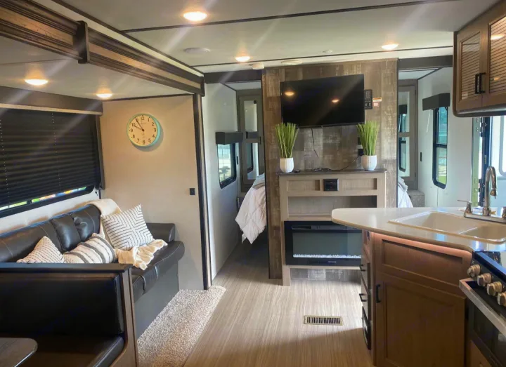 Spacious RV rental interior with a cozy living area, modern kitchen, and comfortable bedroom for memorable travels.. Keystone RV Hideout 2021