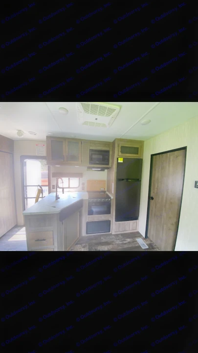 Modern RV rental kitchen interior: compact design with sink, microwave, stove, and fridge. Ideal for travel adventures.. Forest River Cherokee Wolf Pack Toy Hauler 2020