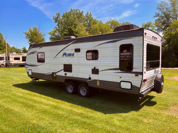 Discover this Puma travel trailer, an ideal RV rental for a sunny camping trip on lush green grass.. Palomino Puma XLE 25 2018