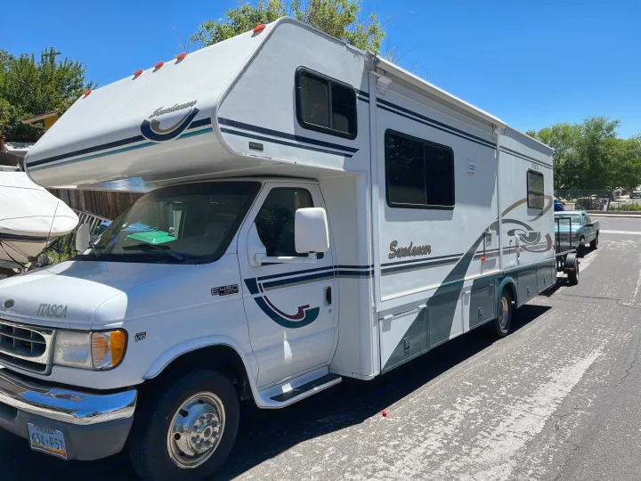 Bright white Itasca Sundancer RV rental with an extended awning. This large motorhome is ready for adventure.. Itasca Sundancer 2001