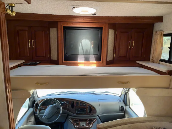 Inside this RV rental: overhead bunk, built-in TV, ample storage, and driver's cockpit. Ready for your next road trip!. Itasca Sundancer 2001