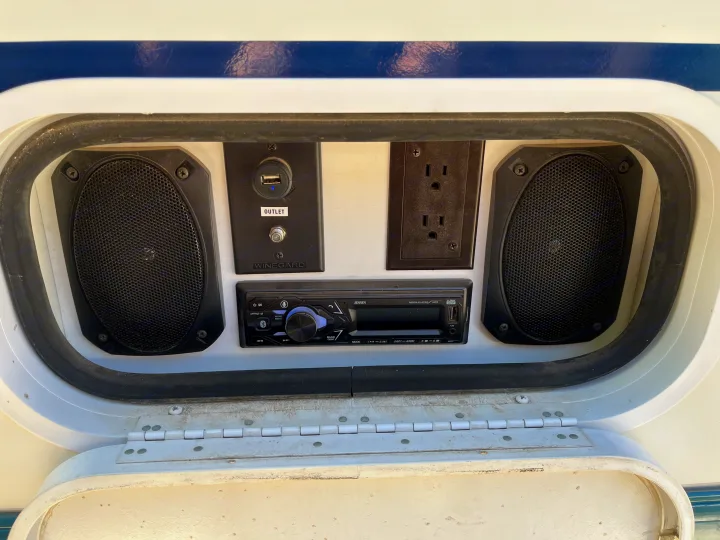 RV rental outdoor entertainment bay: Jensen stereo, dual speakers, USB charging port, and AC outlets.. Itasca Sundancer 2001