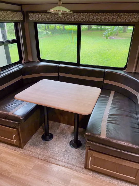 Experience your RV rental's cozy dinette: U-shaped seating, table, storage, and scenic views from wide windows.. Forest River Salem Hemisphere 2020