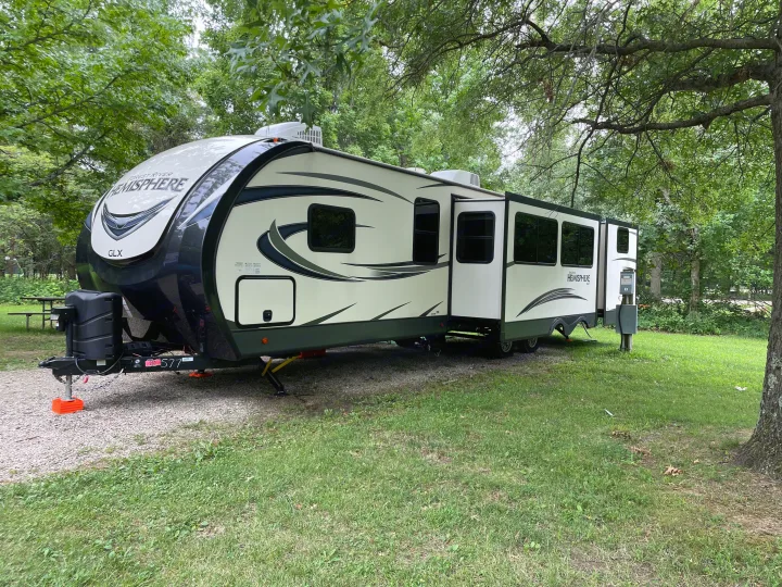 RV rental: Spacious travel trailer parked at a lush, green campsite, surrounded by trees. Perfect for your outdoor adventure.. Forest River Salem Hemisphere 2020