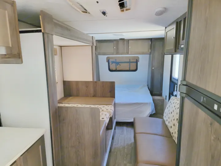 RV rental interior featuring a dinette, bed, refrigerator, and wood-grain cabinets for a comfortable journey.. Clipper Clipper Trailer 2019