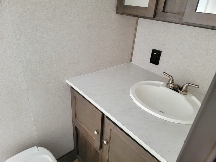 RV rental bathroom vanity featuring a white sink, modern faucet, and light grey textured walls with an electrical outlet.. Clipper Clipper Trailer 2019