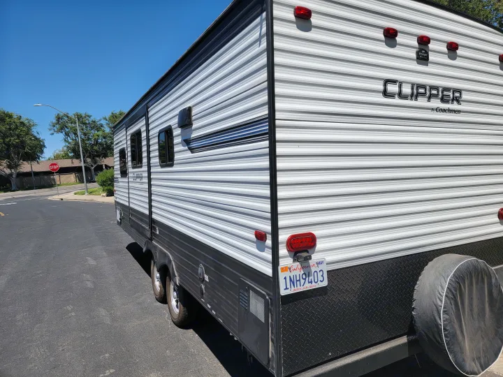 A white and black Coachmen Clipper RV rental, parked on asphalt, shows its rear with red lights & California plate.. Clipper Clipper Trailer 2019