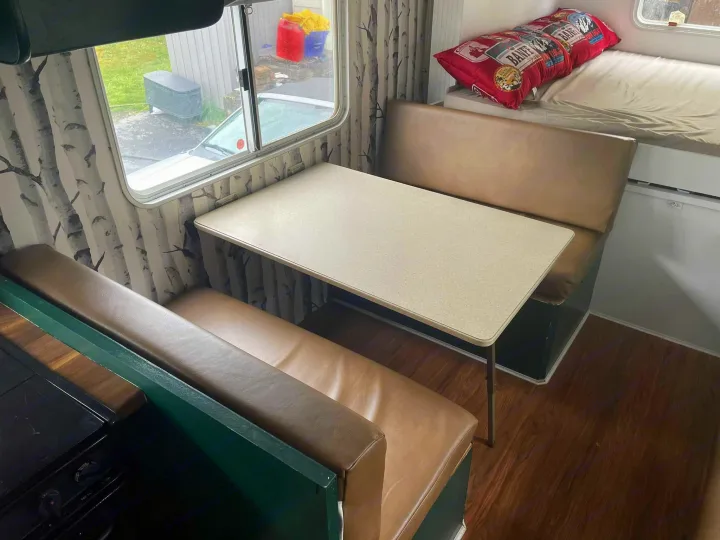 Experience this RV rental's inviting interior: a dinette, compact kitchen, and cozy bunk bed are visible, ready for your trip.. Forest River Surveyor 2006