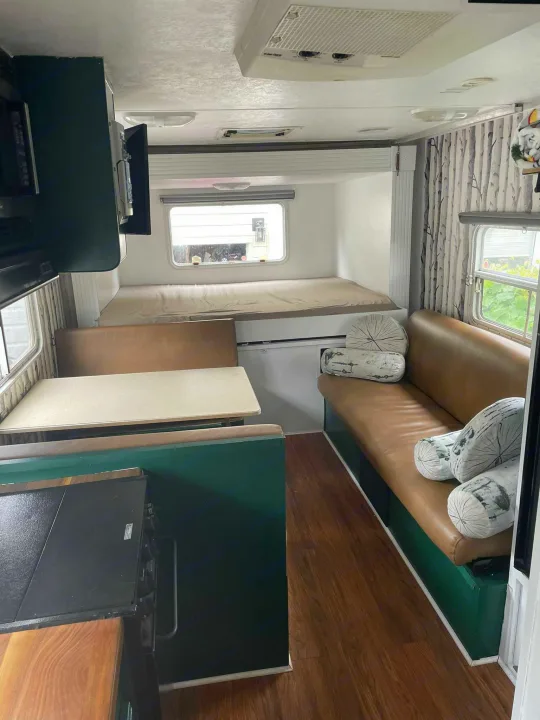 This cozy RV interior offers kitchen, dining, and sleeping areas, perfect for your next rv rental adventure.. Forest River Surveyor 2006