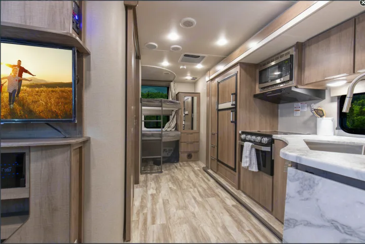 Bright RV rental interior with full kitchen, bunk beds, and TV lounge for comfortable travels.. Grand Design Imagine XLS 19BWE 2020