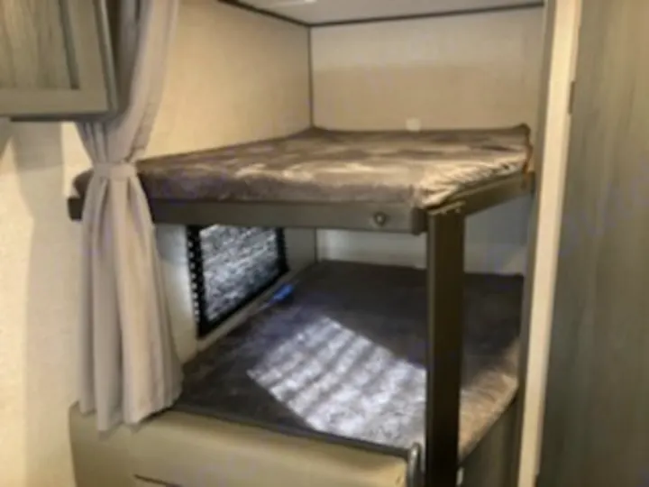 Inside your RV rental: cozy bunk beds with comfy mattresses, offering a practical sleeping space for your next trip.. Dutchmen Other 2022
