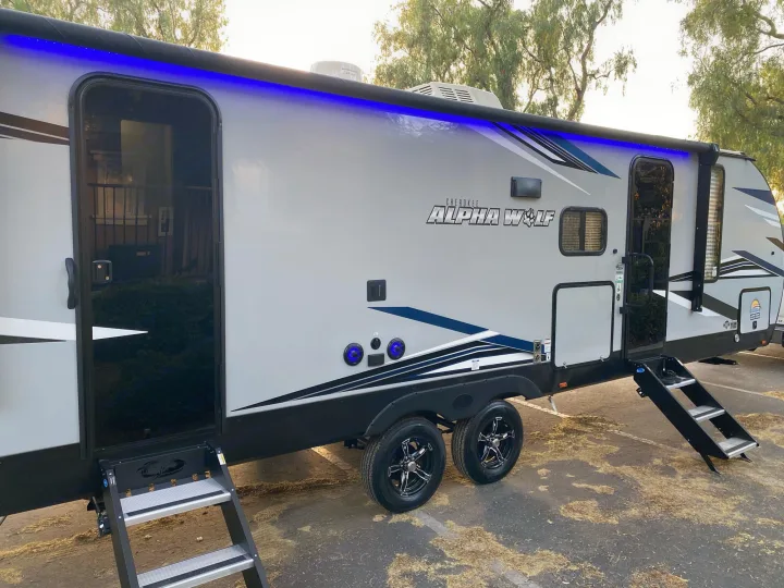 Modern Cherokee Alpha Wolf RV rental with blue LED awning lights and deployable steps, ready for adventure.. Forest River Cherokee 2022