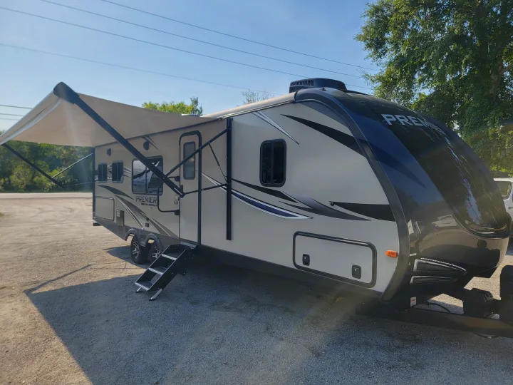 Spacious Premier travel trailer RV rental parked outdoors with awning extended and steps down.. Keystone RV Premier UltraLite 29RKPR 2021