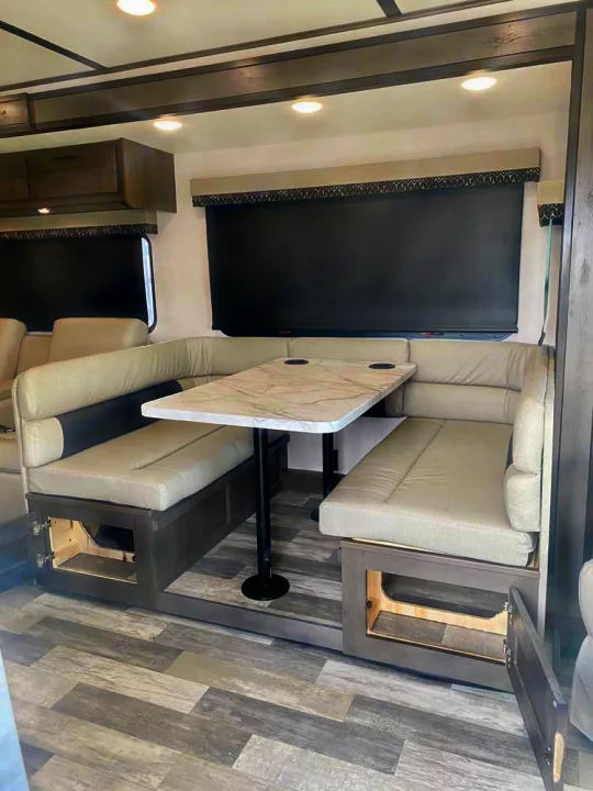 Modern RV rental dinette featuring U-shaped seating, marble-look table, and under-seat storage. Designed for comfortable living on the road.. Forest River FR3 34DL 2020