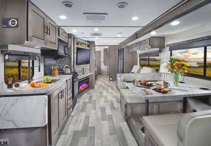 Inside a modern RV rental: a bright, open living space with kitchen, dining area, comfy seating, and scenic views.. Forest River FR3 34DL 2020