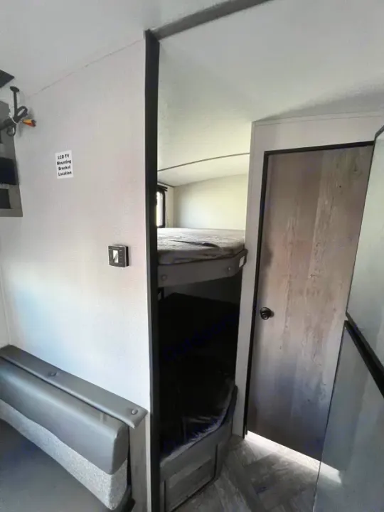Inside this **RV rental**, find a comfortable dinette, practical bunk beds, and access to other living spaces.. Keystone RV Springdale 2021