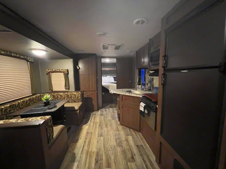 Spacious RV rental interior with a cozy dinette, equipped kitchen, and comfortable bedroom for road trips and adventures.. Keystone RV Hideout 2018