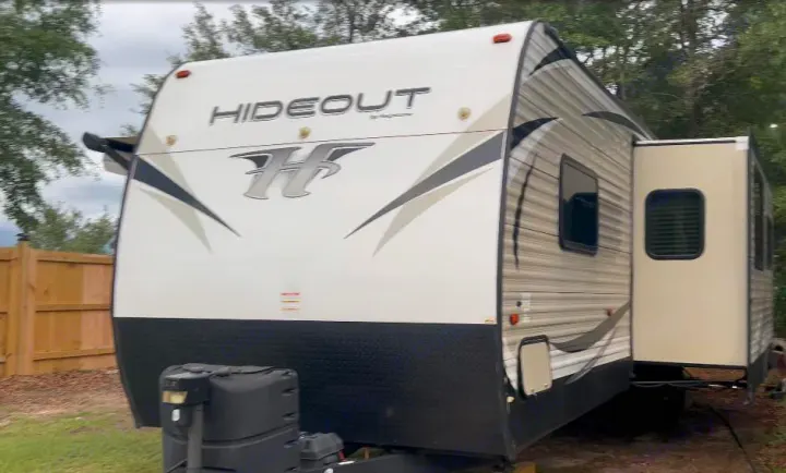 White & grey Hideout travel trailer with a slide-out, ready for your next RV rental outdoor adventure.. Keystone RV Hideout 2018