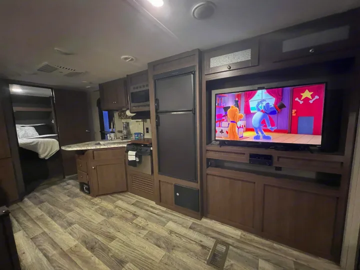 Spacious RV rental interior featuring a living area with TV, full kitchen, and comfortable bedroom. Perfect for travel!. Keystone RV Hideout 2018