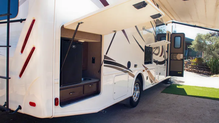 Explore this RV rental's side: open outdoor kitchen with mini-fridge, sink, and extended awning. Perfect for al fresco dining.. Thor Hurricane 2017