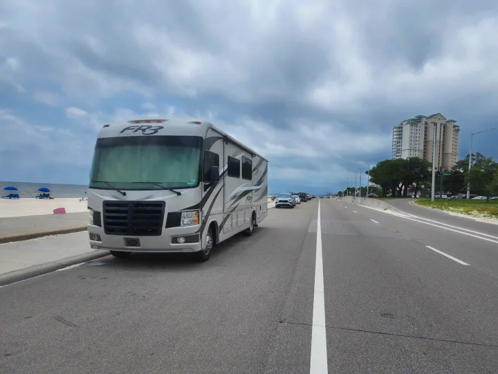 RV rental (FR3) parked on a coastal road next to a sandy beach. Ideal for scenic beach road trips.. Forest River Fr3 2015