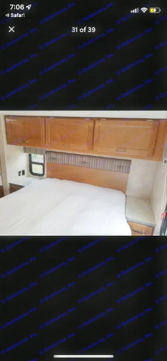RV rental bedroom with a comfortable bed, striped headboard, wooden overhead storage, and a side window.. Winnebago Minnie Winnie 2019