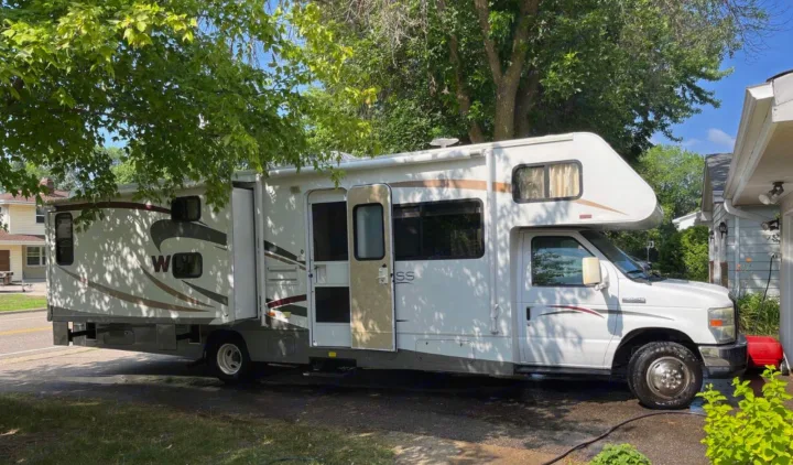 White Class C RV rental, parked on a sunny day with its slide-out extended. This spacious motorhome is ready for adventure.. Winnebago Access 2008