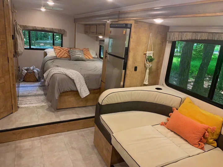 Well-appointed RV rental interior with a cozy bedroom, spacious living area, and a refrigerator.. Forest River Coachmen Leprechaun 2020