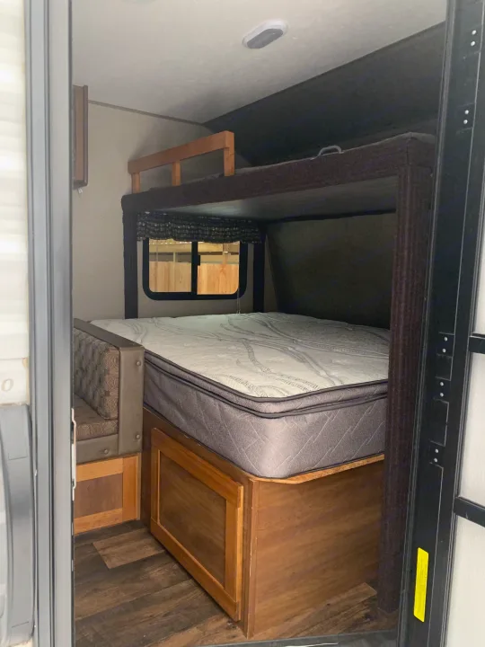 Inside an RV rental: a view of bunk beds, window, and built-in seating, ideal for a cozy trip.. Springdale Summit 2017