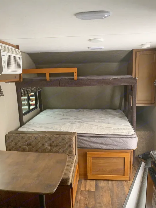 Cozy RV rental interior with a comfy mattress on the lower bunk bed, a dinette, and an AC unit for your travel adventures.. Springdale Summit 2017
