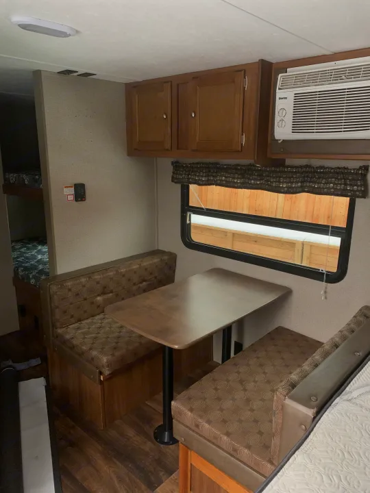 Cozy RV rental interior with a dinette, bunk beds, and AC unit, perfect for family adventures.. Springdale Summit 2017
