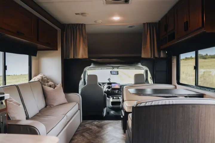 Spacious, modern RV rental interior with a comfortable living area, dinette, and visible driver's cab.. Forester LE 2021