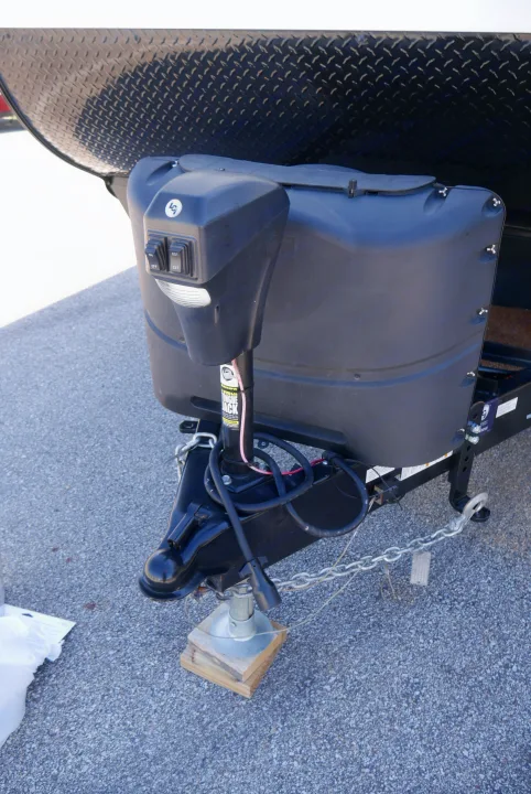 RV rental travel trailer's front: hitch, jack, and propane tank cover detail for towing.. Heartland RVs Trailrunner 2021
