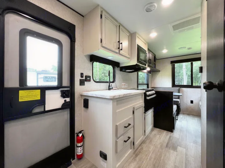Inside this RV rental: bright kitchen, cozy dinette, and entry door. Ready for comfortable travel adventures.. jayco Jay Flight 2022