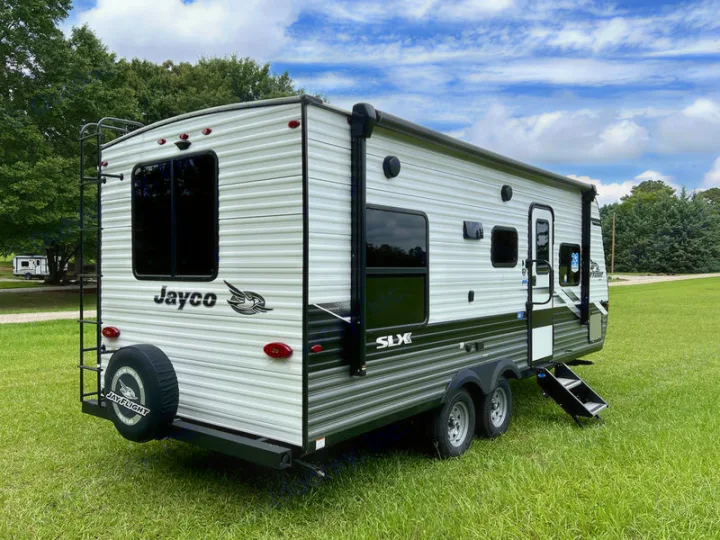 Jayco SLX travel trailer, perfect for your next RV rental adventure, parked on grass under a partly cloudy sky.. jayco Jay Flight 2022