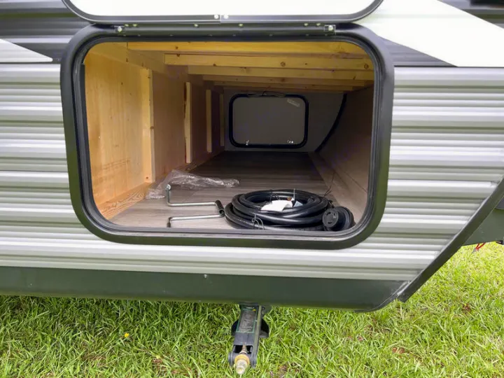 RV rental: Inside a spacious pass-through storage bay of an RV, showing camping gear.. jayco Jay Flight 2022