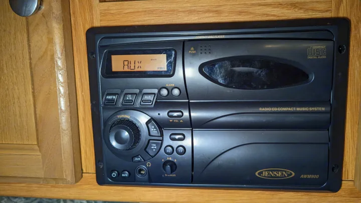 Jensen AWM900 RV stereo system, showing AUX mode on the display, a common feature in an RV rental.. Jayco Jay Feather Sport 2007