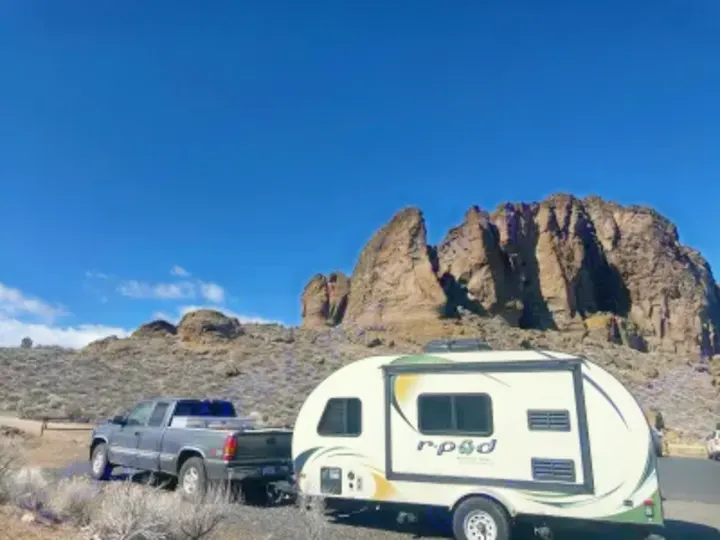 Truck towing an R-Pod travel trailer amidst stunning rock formations under a clear sky. Perfect for an RV rental adventure!. R-Pod Hood River Edition 2015