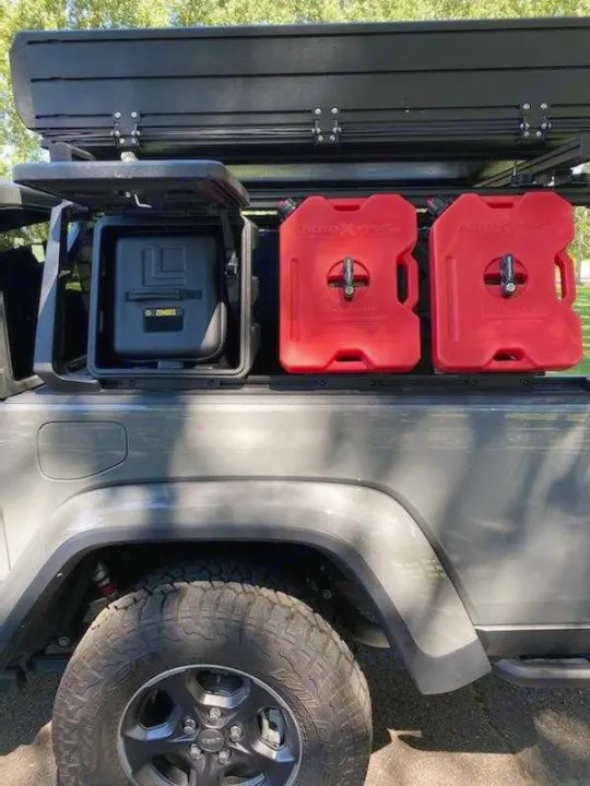 An overlanding rig: grey Jeep with a rooftop tent, red RotopaX, and storage boxes. Ideal for an RV rental for off-road camping.. Other Other 2021