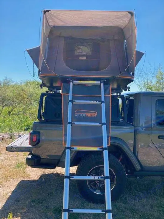 RV rental alternative: A Roofnest rooftop tent with ladder on a Jeep Gladiator truck, ready for outdoor adventures.. Other Other 2021
