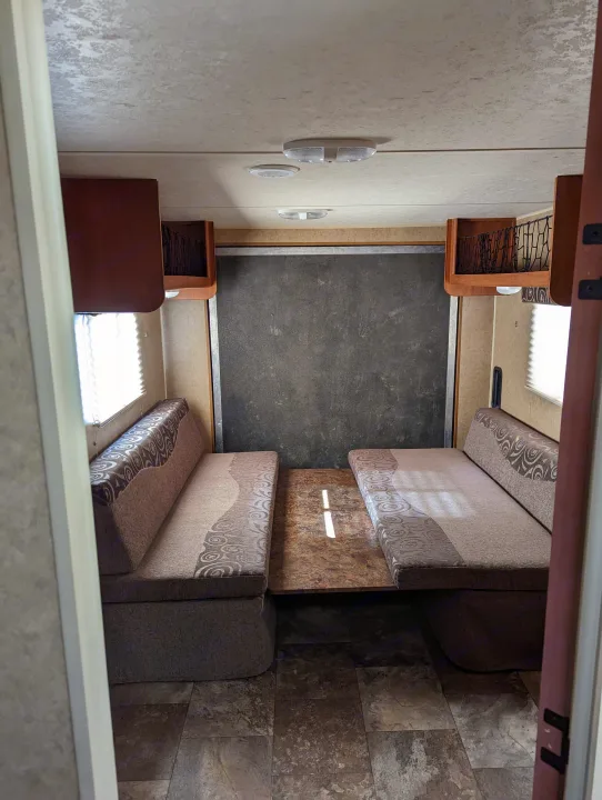 RV rental interior featuring a dinette with two benches and a table. Functional camper living space shown.. Forest River Cherokee Grey Wolf 2015