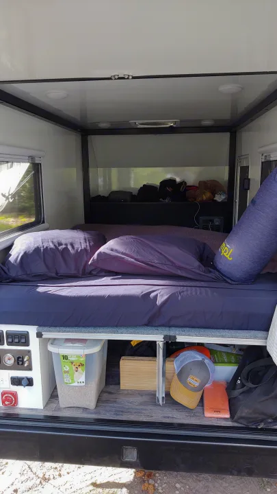 Cozy RV rental interior with bed, pet food, and control panel for comfortable travel.. TetonX Porter 2022