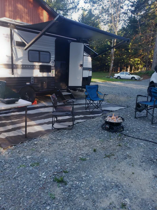 Enjoying an RV rental outdoor setup with a cozy fire pit under the awning. Perfect for a relaxing camping trip!. Keystone RV Hideout 2022