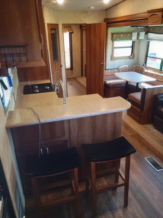 RV rental interior: Bright kitchen island with stools and a comfy U-shaped dining booth.. Crusader Crusader Fifth Wheel 2016
